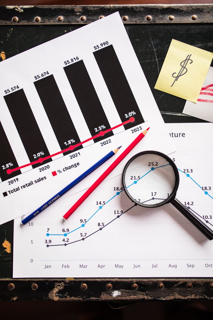 services-01 Financial documents showing charts and graphs with a magnifying glass and pencils for detailed analysis.